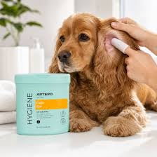 Tub of Artero ear cleaning wipes with a hand cleaning a cocker spaniel's ear