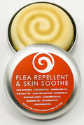 Open tin of Bee Kind Flea Repellent and Skin Soothe balm showing the swirled beeswax balm and orange lid label