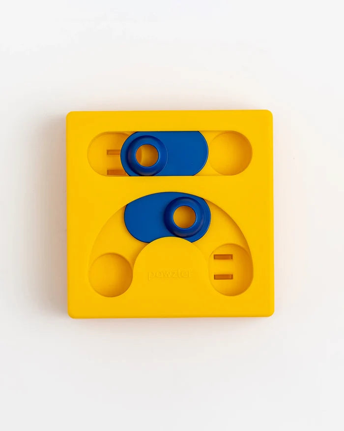 Yellow Pawzler Kaya puzzle piece with sliding blue covers over treat holes, empty
