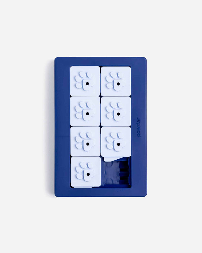 Navy blue Pawzler Louvre puzzle tray with white paw-print sliding tiles, overhead view