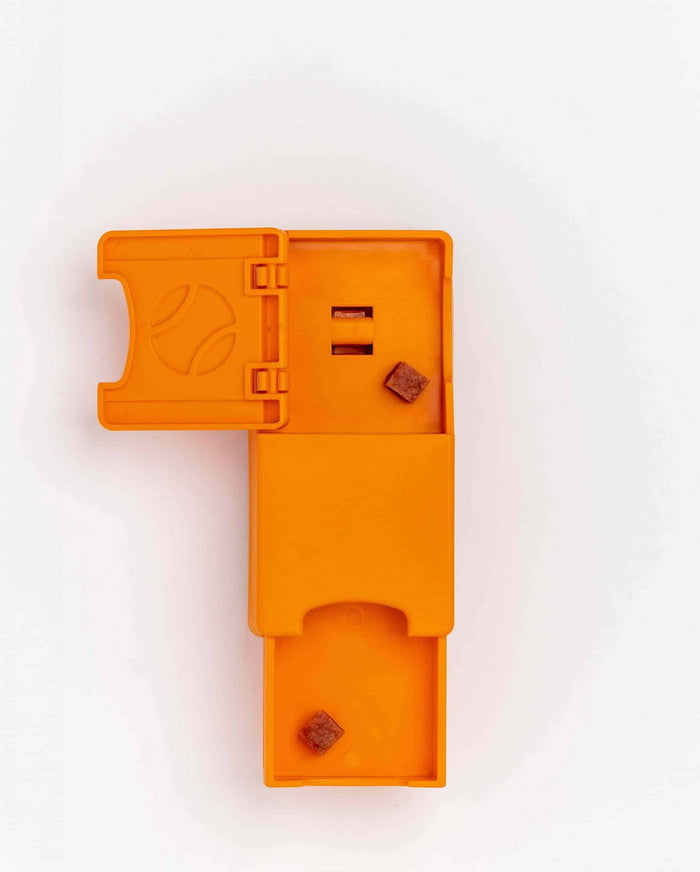 Orange Pawzler Maya puzzle piece opened to show its hidden treat compartment