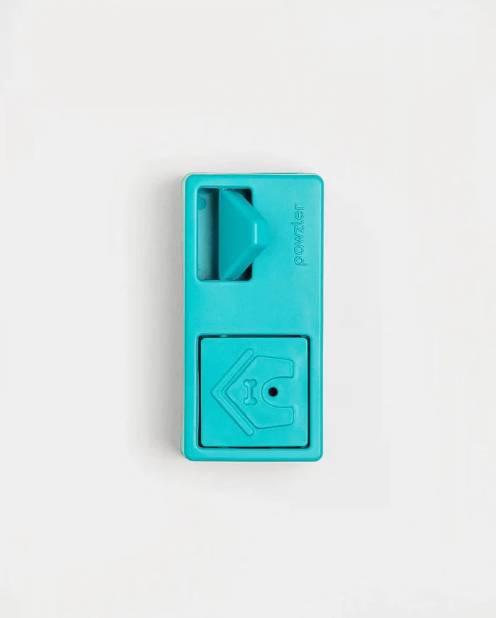Closed teal Pawzler Nai puzzle piece with sliding door and bone-icon door, top-down view