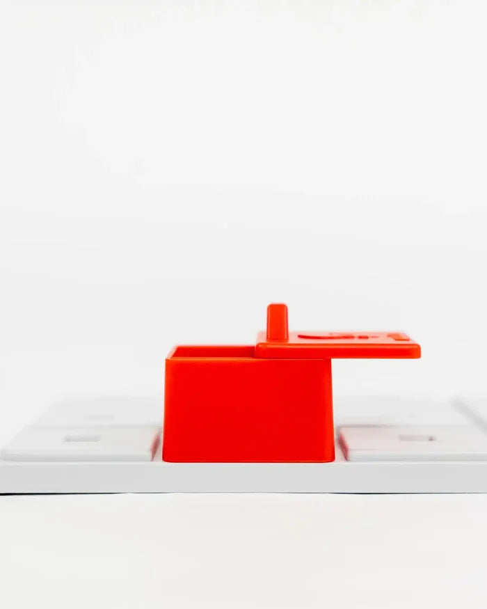 Side view of the red Pawzler Peach puzzle piece with its lid open