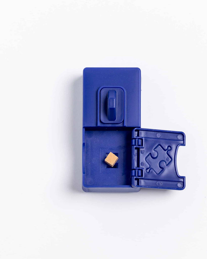 Open navy blue Pawzler Sela puzzle piece with a puzzle-piece shaped door and treat inside