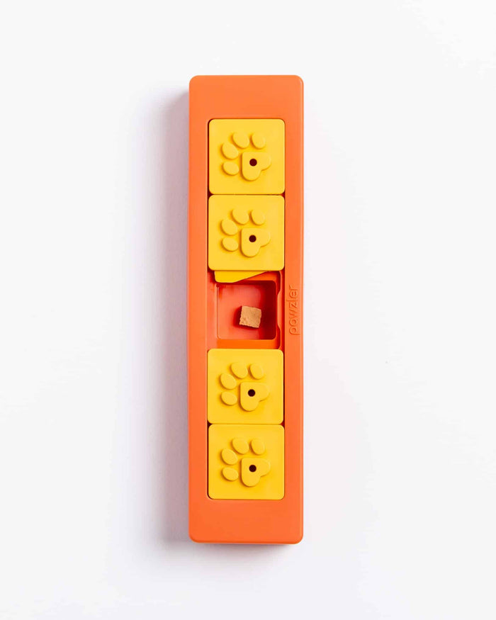 Orange Pawzler Zhu puzzle piece with two flower tiles removed, revealing a hidden treat