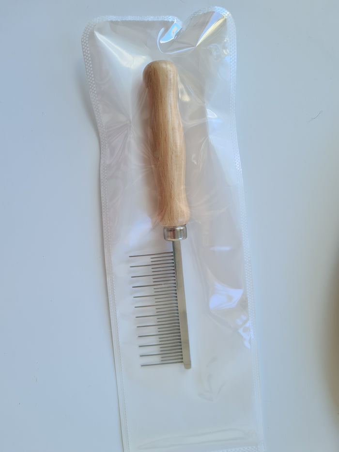 Wooden-handled shedding comb with fine metal teeth in its packaging