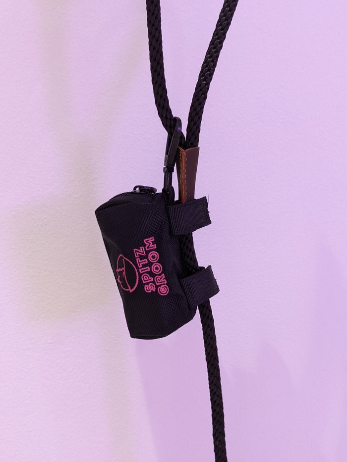 Close-up of the Spitz Groom poo bag holder clipped onto a rope lead with a carabiner